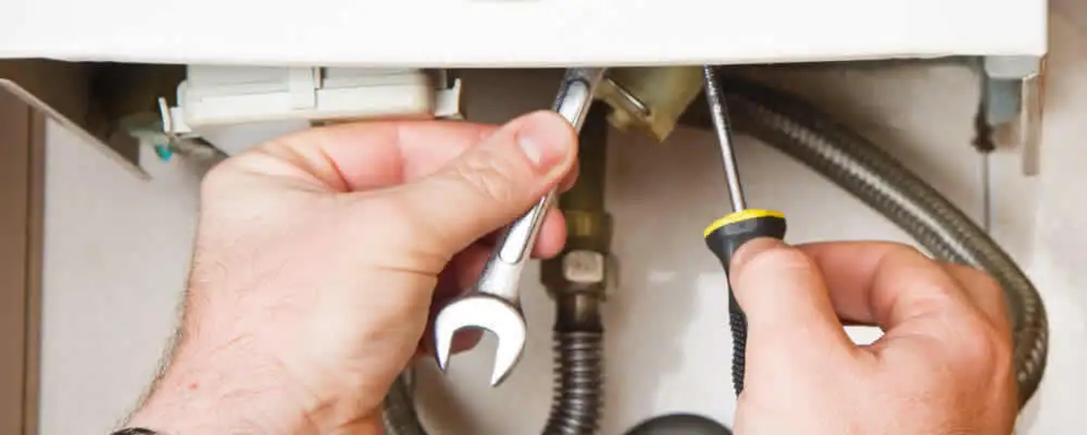 Boiler repair technician tightening pipe fittings and connections in Charleston, SC