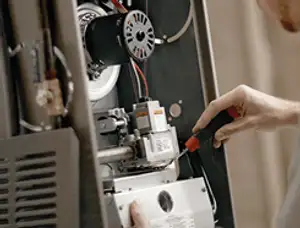 Furnace repair technician inspecting internal components and wiring in Charleston, SC
