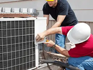 HVAC technicians repairing an outdoor AC unit on a rooftop in Charleston, SC