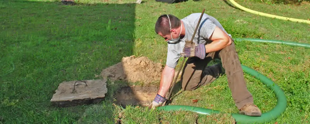 Septic pumping technician servicing a residential septic tank in Charleston, SC