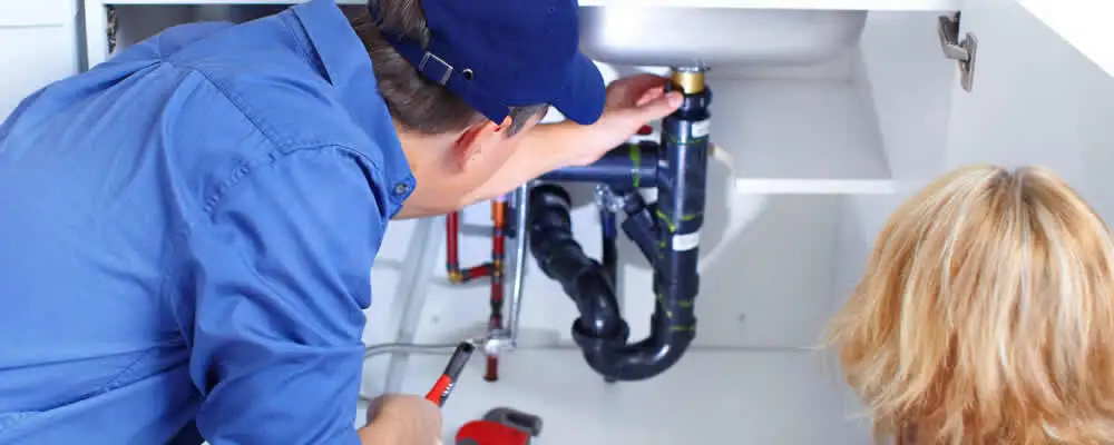 Plumber repairing under-sink drain pipes and fittings in Charleston, SC